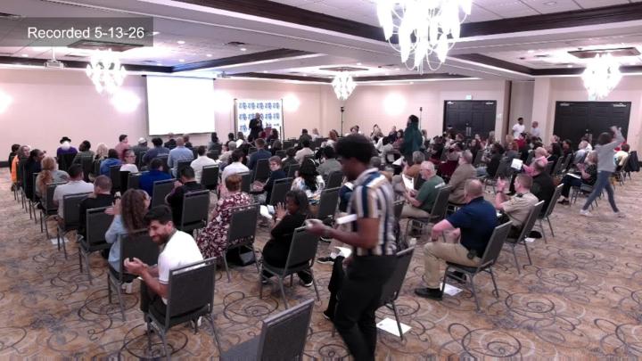 Wide shot of audience at Coalition Meeting. 